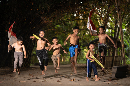 Concept photo of village children who are excited and play in the Indonesian independence edition carrying the flag. : Bantul, Indonesia - 15 August 2021のeditorial素材