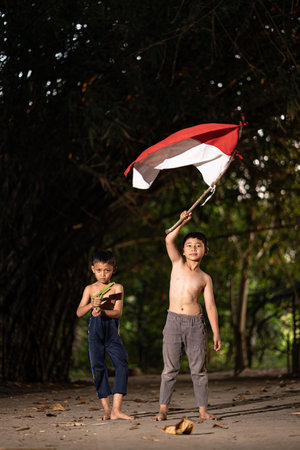 Concept photo of village children who are excited and play in the Indonesian independence edition carrying the flag. : Bantul, Indonesia - 15 August 2021のeditorial素材