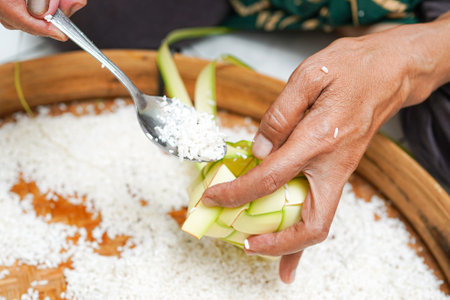 The process of making ketupat is a traditional food during Eid. Put the rice in the ketupat container.の写真素材