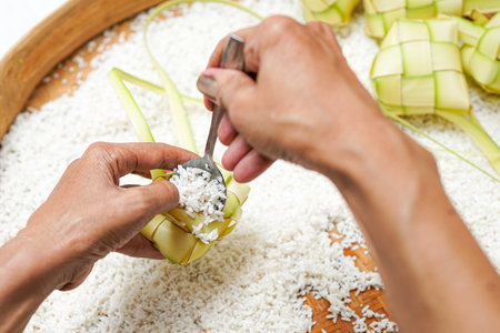 The process of making ketupat is a traditional food during Eid. Put the rice in the ketupat container.の写真素材