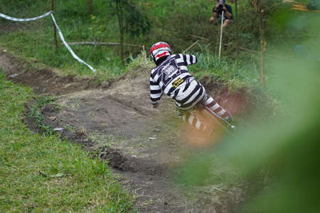 Downhill Bike Festival in Yogyakarta "Teras CAF". A participant of the Mountain Bike Festival is seen from behind cycling down the hill fast and agile. : Sleman, Indonesia - 28 May 2022のeditorial素材