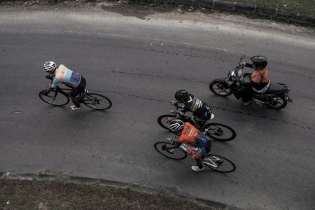 A group of road bike athletes from Mula and Nusantara pro cycling competed on the road, preparing...