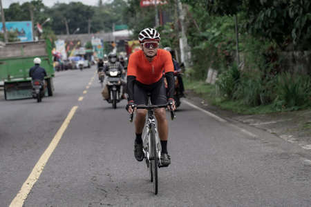 Expression and style of professional road bike cyclists through the downhill route, preparing for the test route for the Tour de ambarrukmo 2022. : Sleman, Indonesia - 21 May 2022のeditorial素材