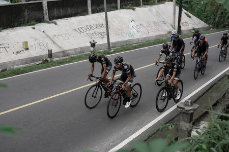Professional road bike cyclists pass the background scenery of Prambanan temple, preparing for the...