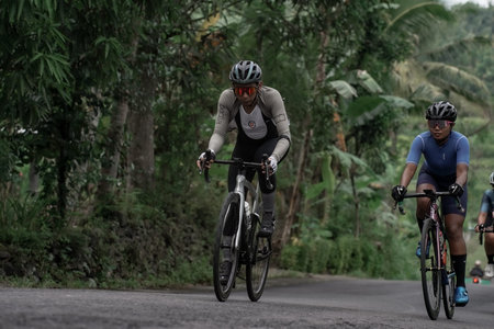 Professional road bike cyclists pass the background scenery of Prambanan temple, preparing for the...