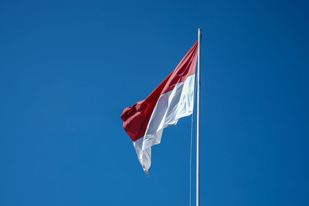 Indonesian flag with blue sky background.の写真素材