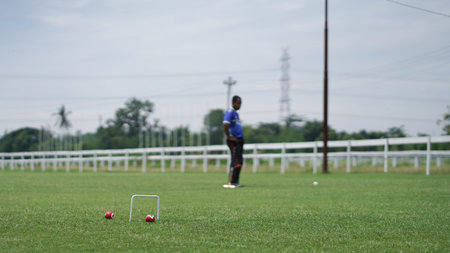 The gateball player's feet and their tools on the grass field.