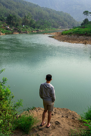 Beautiful view of a quiet river surrounded by fresh green grass and trees.の写真素材