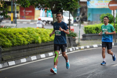 Yogyakarta, Indonesia - October 30, 2022 : running participants who pass through the streets of the city of Yogyakarta, they take part in the "Klik Dokter Run Fest 2022" running competition.のeditorial素材