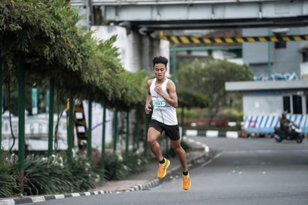 Yogyakarta, Indonesia - October 30, 2022 : running participants who pass through the streets of the city of Yogyakarta, they take part in the "Klik Dokter Run Fest 2022" running competition.のeditorial素材