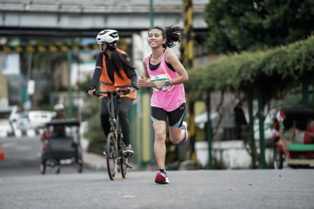 Yogyakarta, Indonesia - October 30, 2022 : running participants who pass through the streets of the city of Yogyakarta, they take part in the "Klik Dokter Run Fest 2022" running competition.のeditorial素材