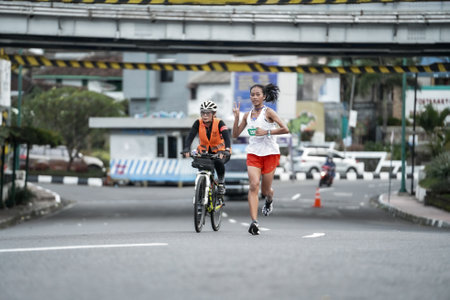 Yogyakarta, Indonesia - October 30, 2022 : running participants who pass through the streets of the city of Yogyakarta, they take part in the "Klik Dokter Run Fest 2022" running competition.のeditorial素材