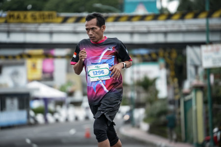Yogyakarta, Indonesia - October 30, 2022 : running participants who pass through the streets of the city of Yogyakarta, they take part in the "Klik Dokter Run Fest 2022" running competition.のeditorial素材