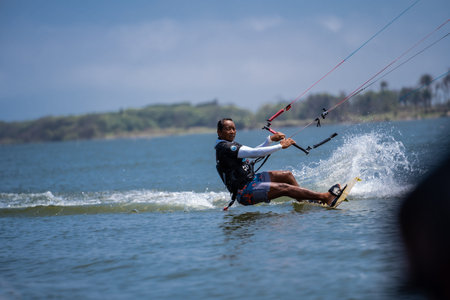 kitesurfing. A male surfer rides on a beautiful backdrop of bridges and coastlines and performs all...