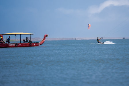kitesurfing. A surfer rides against a backdrop of beautiful bridges and coastlines and performs all kinds of stunts. Sport, health, leisure concept. : Yogyakarta, Indonesia - 26 August 2023のeditorial素材