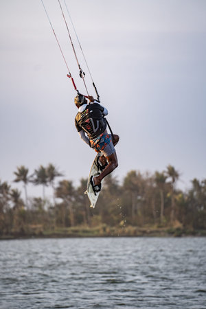 kitesurfing. A surfer doing all kinds of stunts at sunset. International Kitesurfing Exhibition...
