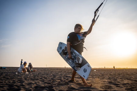 Kitesurfing surfers walk towards the beach and are about to perform stunts in the sea. : Yogyakarta,...