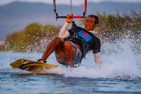 kitesurfing. A surfer rides against a backdrop of beautiful bridges and coastlines and performs all kinds of stunts. Sport, health, leisure concept. : Yogyakarta, Indonesia - 26 August 2023のeditorial素材