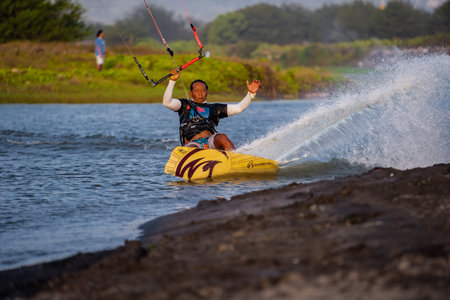 kitesurfing. A male surfer rides on a beautiful backdrop of bridges and coastlines and performs all...