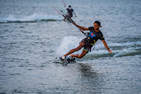 kitesurfing. A male surfer rides on a beautiful backdrop of bridges and coastlines and performs all...