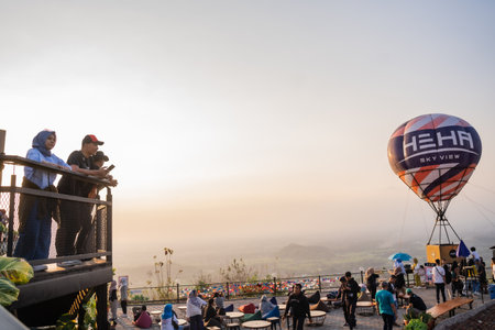tourists enjoy the sunset at the tourist destination offering the best view in Yogyakarta, namely Heha Skyview. : Yogyakarta, Indonesia - 24 August 2023のeditorial素材