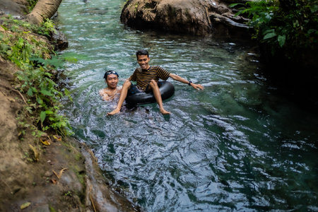 tourists play and enjoy swimming as well as using float tubes, being in the spring river. Udal Gumuk...
