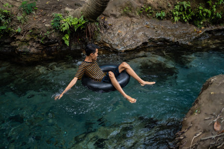 tourists play and enjoy swimming as well as using float tubes, being in the spring river. Udal Gumuk...