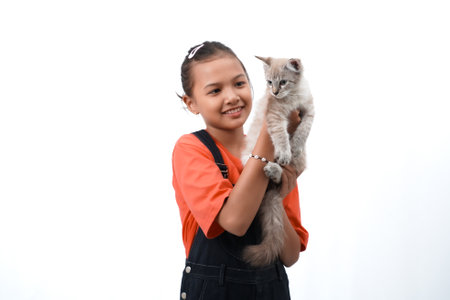 Asian girl holding a cute, adorable and funny kitten. Isolated on white background. International cat day concept.の写真素材