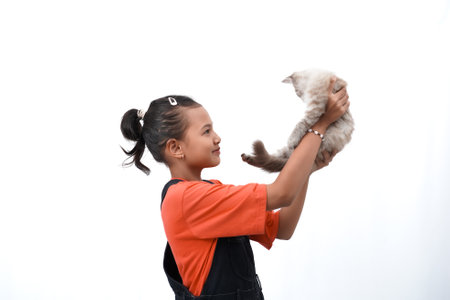 Asian girl holding a cute, adorable and funny kitten. Isolated on white background. International cat day concept.の写真素材