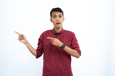 asian man, businessman or student concept wearing red casual shirt posing looking to the side of copy space with happy or surprised face. Isolated white background.の写真素材