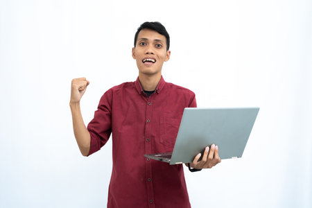 asian man, businessman or student concept wearing red casual clothes elegant pose carrying a minimalist laptop. Isolated white background.の写真素材