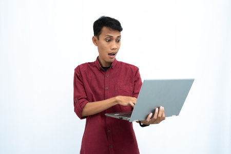 asian man, businessman or student concept wearing red casual clothes elegant pose carrying a minimalist laptop. Isolated white background.の写真素材