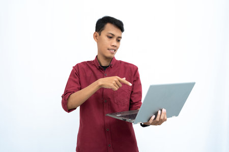 asian man, businessman or student concept wearing red casual clothes elegant pose carrying a minimalist laptop. Isolated white background.の写真素材