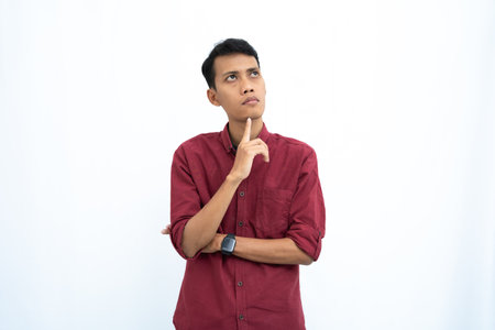 asian man, business or student concept wearing red casual shirt thinking pose, looking for ideas, getting ideas, confused. Isolated white background.の写真素材