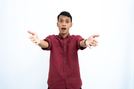 Asian man, businessman or student concept wearing red casual clothes poses pointing at you. Isolated white background.の写真素材
