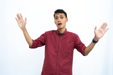 asian man wearing red casual shirt giving warm greeting pose. Isolated white background.の写真素材