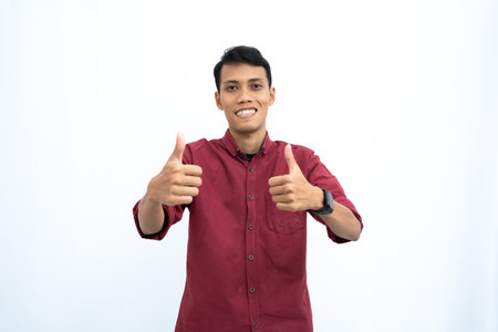 asian man, businessman or student concept wearing red casual shirt showing thumbs up that agree, okay. Isolated white background.の写真素材