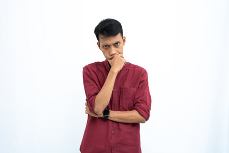 asian man, business or student concept wearing red casual shirt thinking pose, looking for ideas, getting ideas, confused. Isolated white background.の写真素材