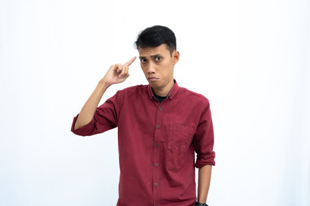 asian man, business or student concept wearing red casual shirt thinking pose, looking for ideas, getting ideas, confused. Isolated white background.の写真素材