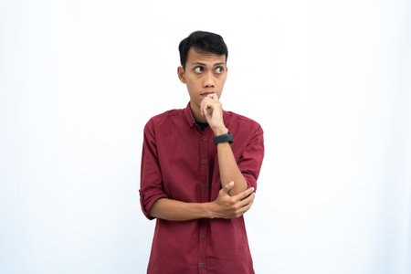 asian man, business or student concept wearing red casual shirt thinking pose, looking for ideas, getting ideas, confused. Isolated white background.の写真素材