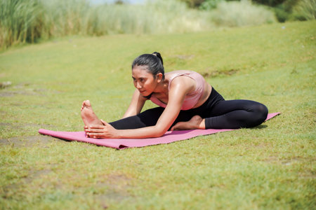 Mental and physical health. A slender, tanned Asian woman in sportswear performs yoga on a calm...