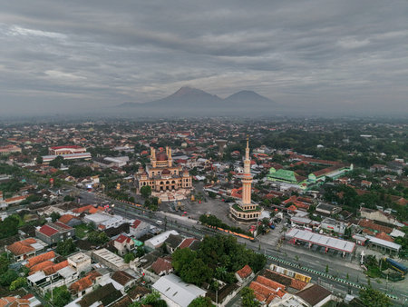 Aerial photo of a mosque in Klaten with a beautiful view of Mount Merapi and Mount Merbabu in the...