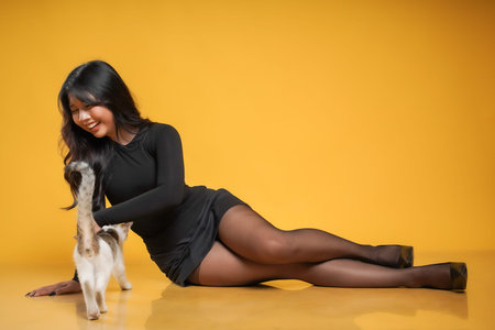 concept photo of beautiful asian woman casual wearing black dress isolated on yellow background