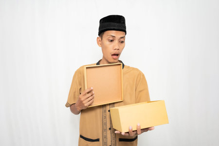 Asian delivery man in uniform holding boxes