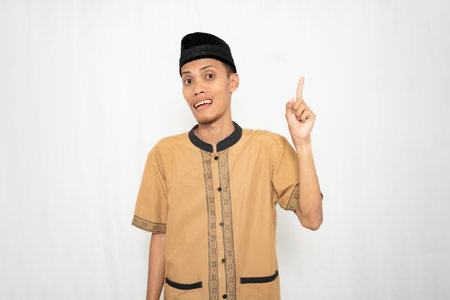 A young man wearing traditional attire pointing upwards