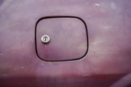 Close-up view of a car fuel door with a metal cap