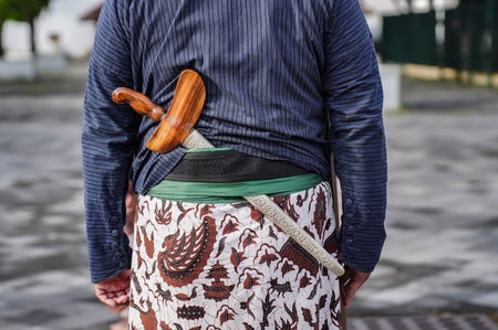 a keris inserted between Yogyakarta traditional clothes.