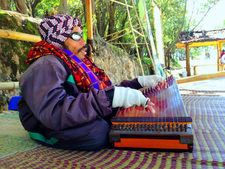 A man playing traditional guitar from indonesia called kecapiの素材
