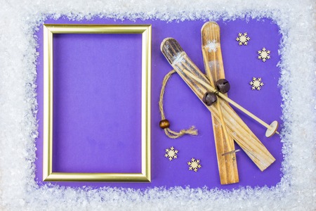 Christmas frame consists of a white embellishments: snowflakes, reindeer, ski and gift boxes on a...