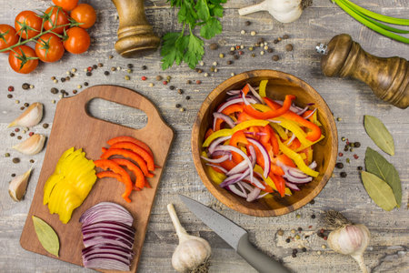 Ingredients for food onion pepper garlic and utensils on a wooden table. A top view of a plate of vegetables greens, for copy spaceの写真素材